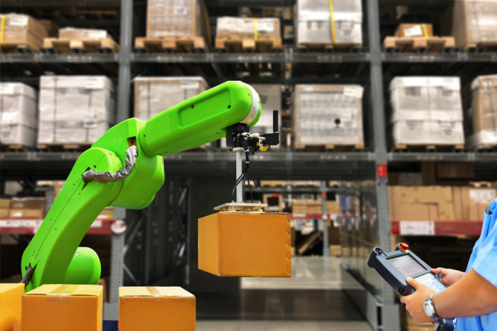 Robotic arm lifting a box in a warehouse, representing SVT Robotics’ SOFTBOT Platform surpassing 4 billion lifetime transactions.