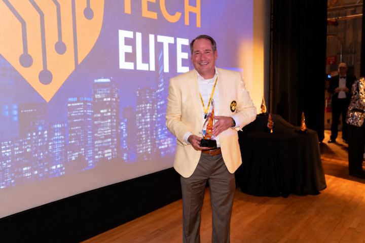 Jay Livingood, founder of Yellow Dog Software, holding a glass award at 757 TechNite.