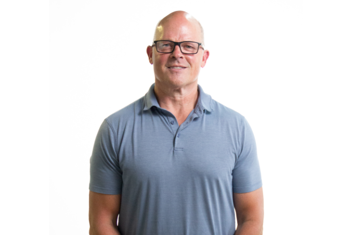 Al MacIsaac, former Chicago Blackhawks front office leader, standing in front of a white wall